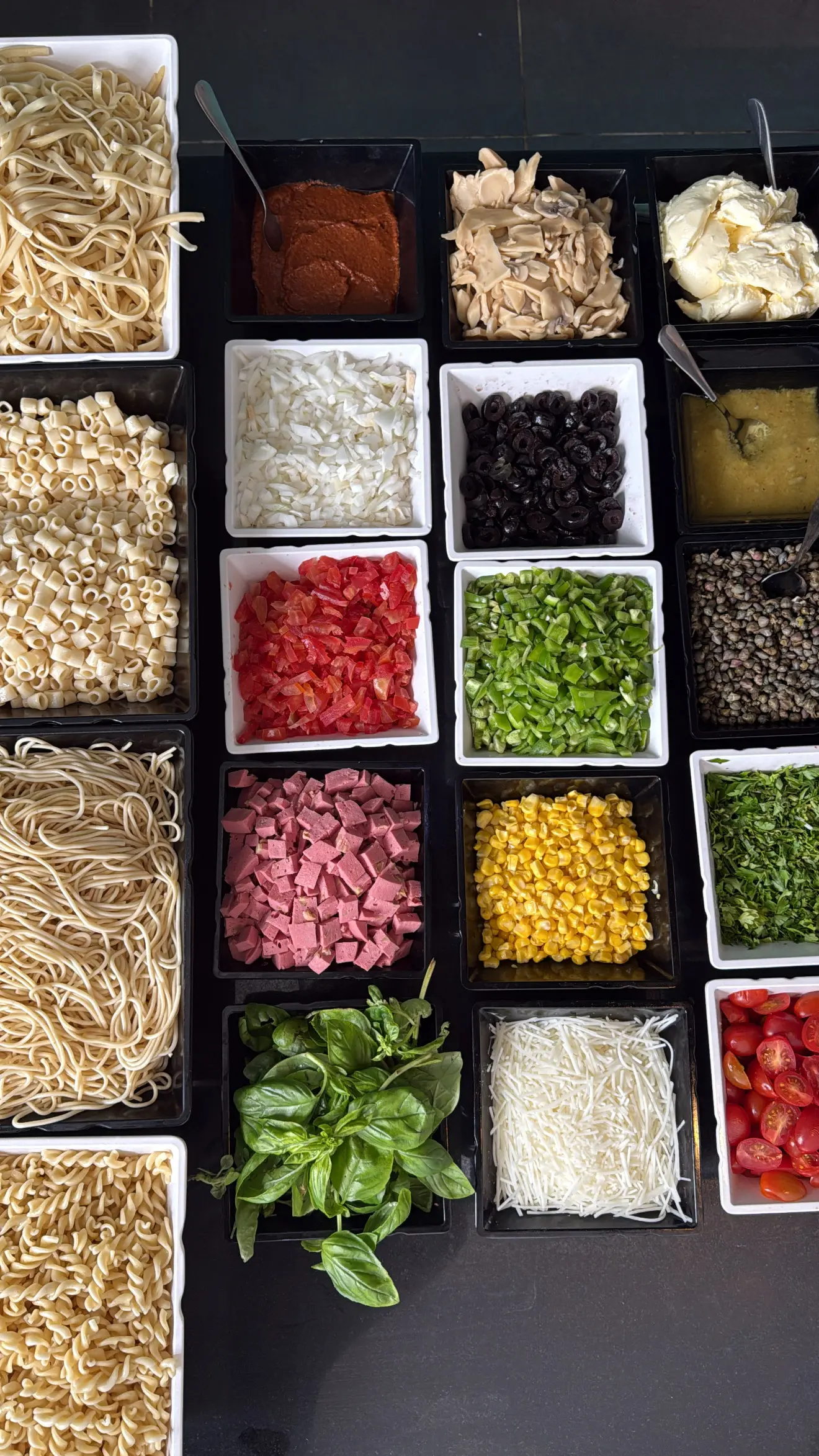 Station pâtes du buffet avec garnitures variées, légumes frais et herbes au restaurant de l'Hôtel Hammamet Beach, Tunisie