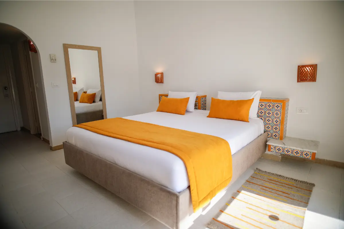 Lit double king size avec tête de lit en zellige tunisien dans le bungalow de l'Hôtel Hammamet Beach, Hammamet Tunisie