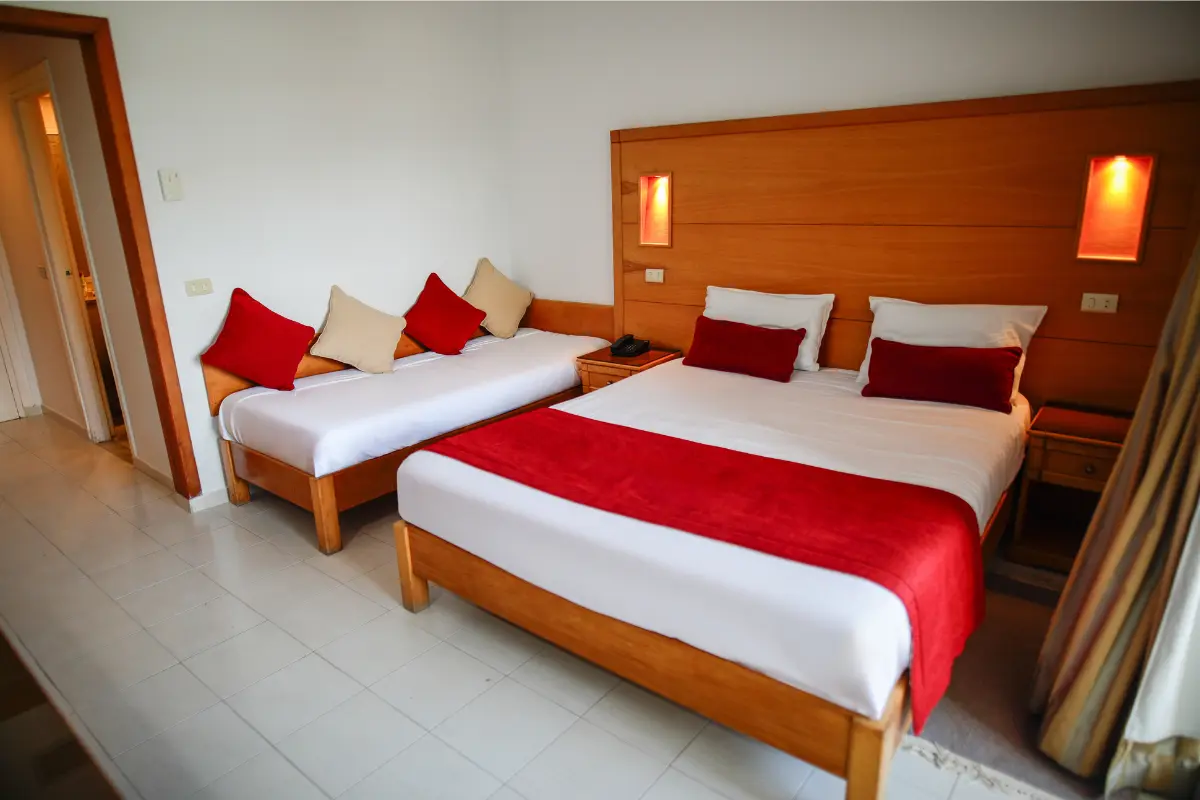 Chambre standard twin avec deux lits jumeaux et tête de lit en bois à l'Hôtel Hammamet Beach, Hammamet Tunisie