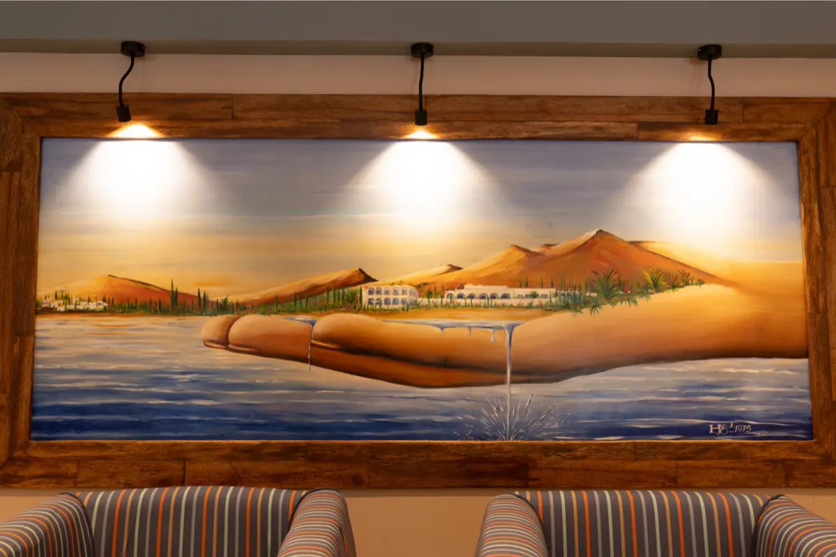 Peinture murale originale de 1975 représentant l'Hôtel Hammamet Beach dans un paysage tunisien, exposée dans le lobby