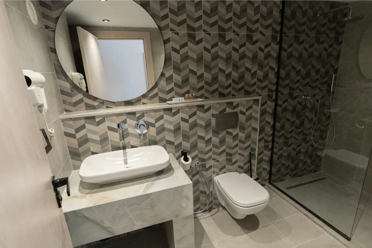 Salle de bain complète avec vasque marbre, WC suspendu et douche italienne vitrée à l'Hôtel Hammamet Beach, Hammamet Tunisie