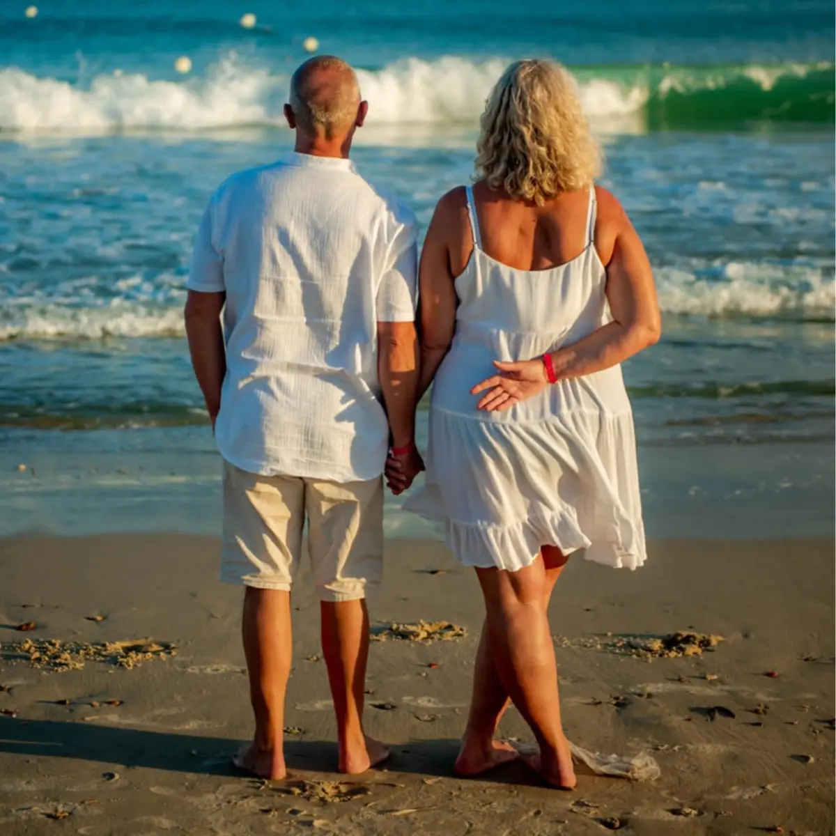 Couple se promenant main dans la main sur la plage de l'Hôtel Hammamet Beach au coucher du soleil, Hammamet Tunisie